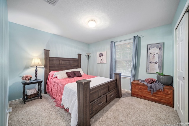 carpeted bedroom featuring a closet and a textured ceiling