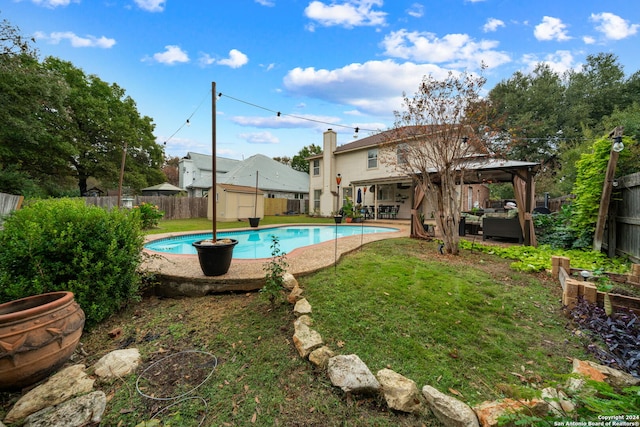 view of swimming pool featuring a gazebo, a yard, and a storage shed