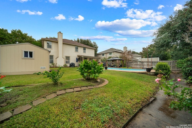 view of yard with a fenced in pool and a gazebo