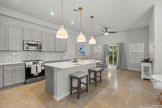 1002 Morningside Dr Unit 6, Terrell Hills, TX 78209 - kitchen featuring appliances with stainless steel finishes, decorative light fixtures, ceiling fan, and an island with sink