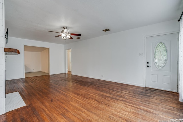 unfurnished living room featuring ceiling fan and dark wood-type flooring