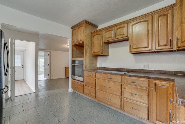 kitchen with appliances with stainless steel finishes and a textured ceiling