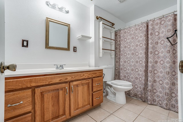 bathroom with tile patterned flooring, vanity, and toilet