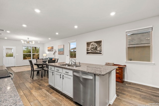 kitchen with stainless steel dishwasher, sink, wood-type flooring, a center island with sink, and white cabinets