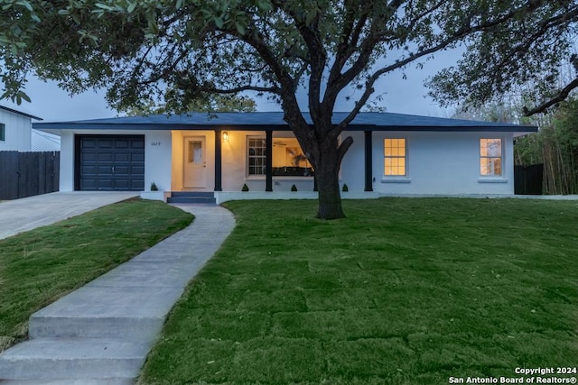 ranch-style house featuring a front yard and a garage