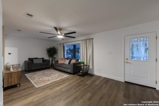 living room with ceiling fan and dark wood-type flooring