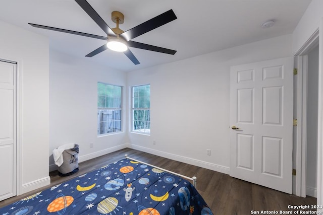 unfurnished bedroom with ceiling fan and dark wood-type flooring