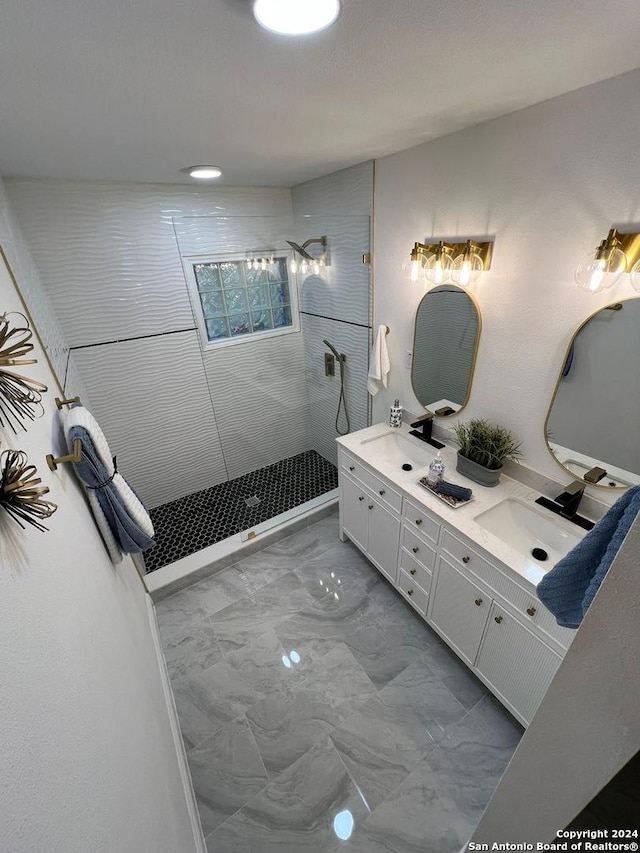 bathroom with vanity and tiled shower