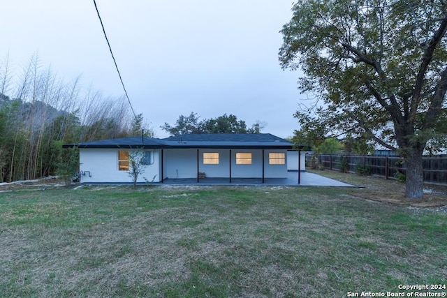 rear view of property with a lawn and a patio area