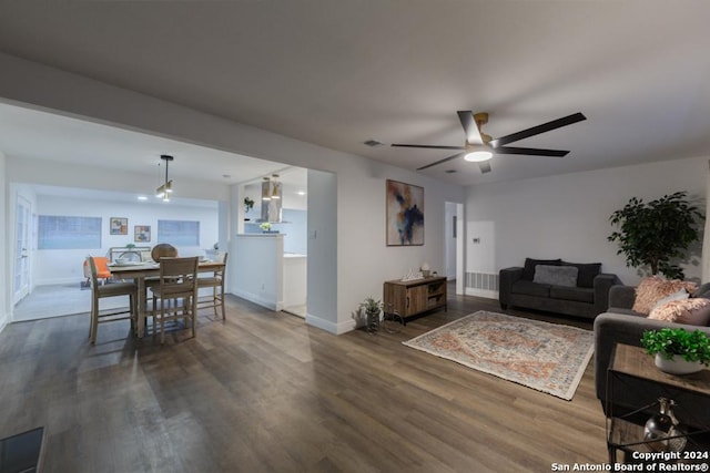 living room featuring ceiling fan and dark hardwood / wood-style flooring