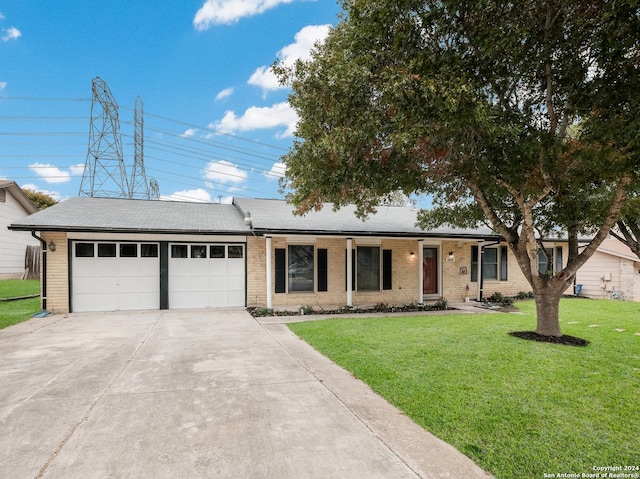 ranch-style house featuring a front lawn and a garage