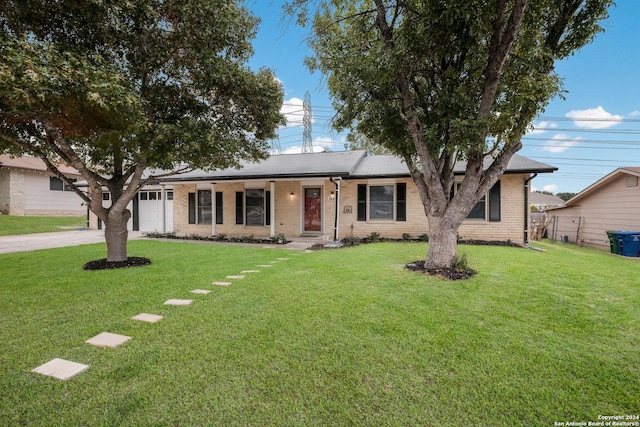 single story home featuring a porch, a front yard, and a garage