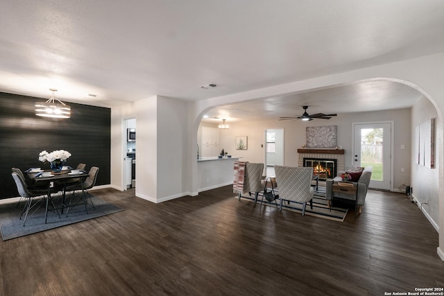 dining space with dark hardwood / wood-style floors, ceiling fan, and a fireplace