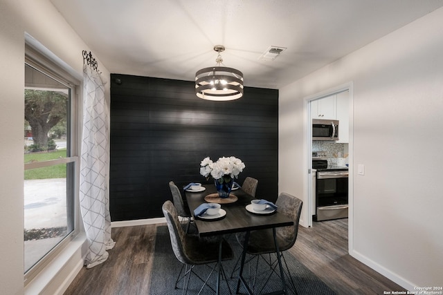 dining area featuring dark hardwood / wood-style floors and an inviting chandelier