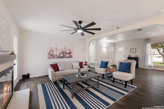 living room with ceiling fan, a fireplace, and dark hardwood / wood-style floors