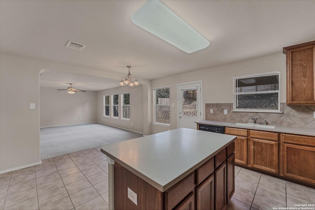 kitchen featuring decorative backsplash, a center island, hanging light fixtures, and light tile patterned flooring