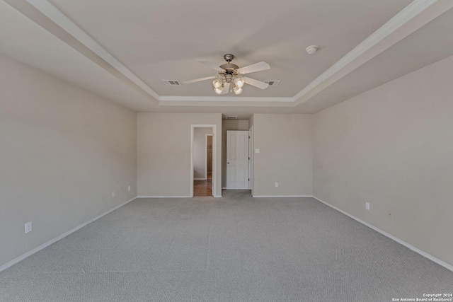 carpeted empty room with ceiling fan and a raised ceiling