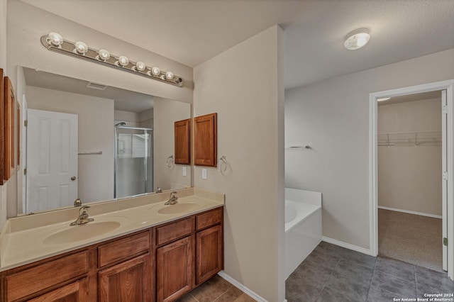 bathroom with tile patterned floors, vanity, a textured ceiling, and independent shower and bath