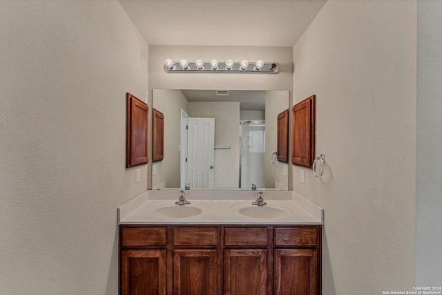 bathroom with vanity and a shower with door