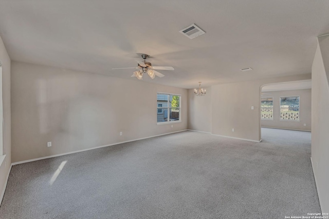 spare room with light colored carpet and ceiling fan with notable chandelier