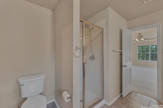 bathroom featuring tile patterned floors, ceiling fan, a shower with shower door, and toilet