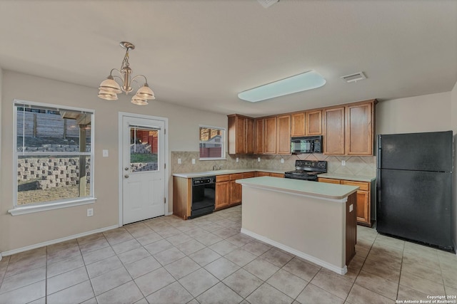 kitchen featuring hanging light fixtures, a chandelier, decorative backsplash, a kitchen island, and black appliances