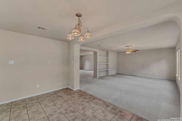 carpeted spare room with ceiling fan with notable chandelier