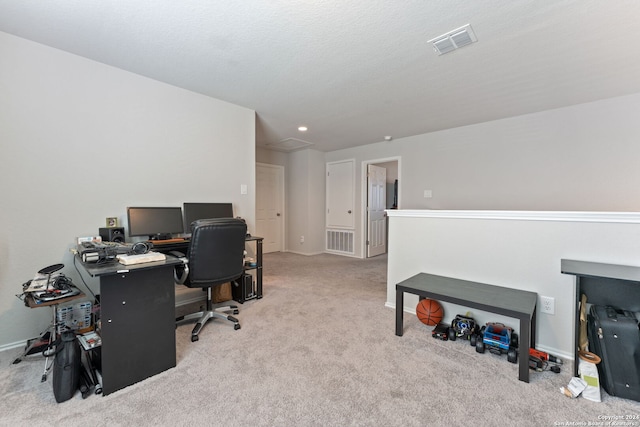 carpeted office space featuring a textured ceiling