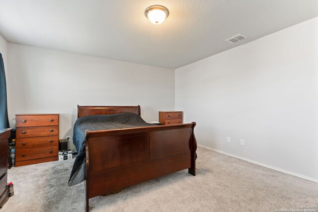 carpeted bedroom featuring a textured ceiling