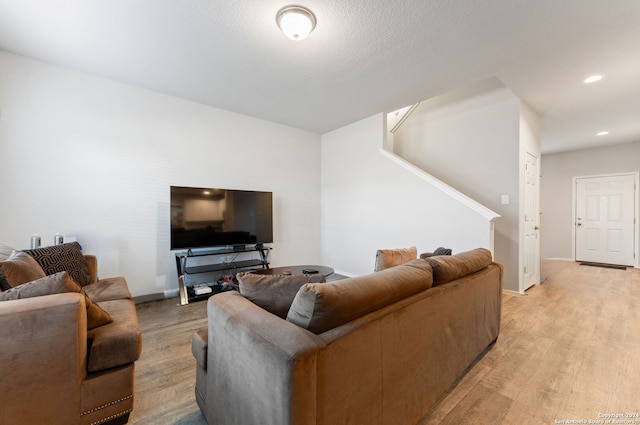 living room with light hardwood / wood-style floors and a textured ceiling