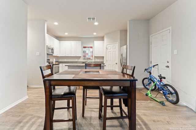 dining area with light hardwood / wood-style flooring and sink