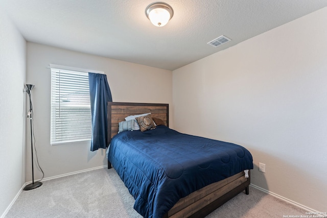 bedroom with carpet and a textured ceiling