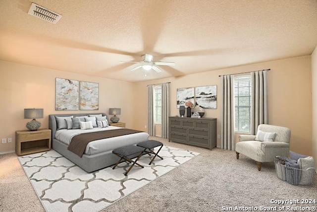 carpeted bedroom featuring a textured ceiling and ceiling fan