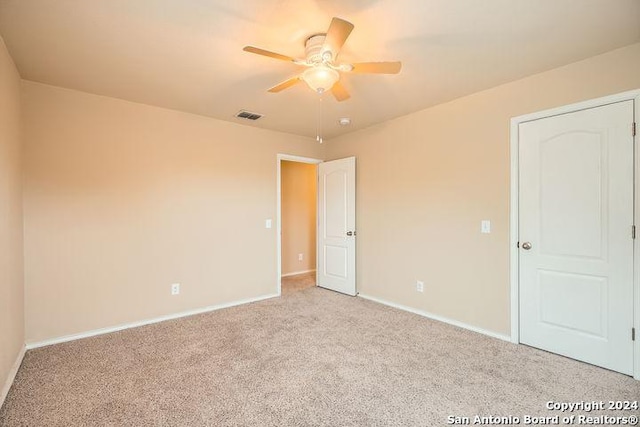 carpeted spare room with ceiling fan