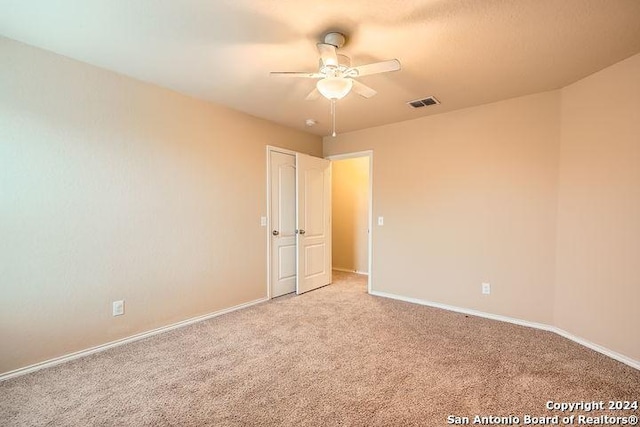 spare room featuring light carpet and ceiling fan