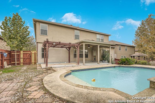 rear view of property with ceiling fan, a patio area, a fenced in pool, and a pergola