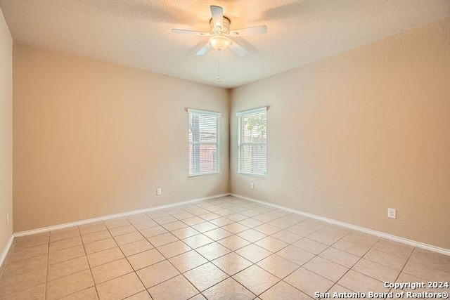 empty room featuring ceiling fan and light tile patterned floors