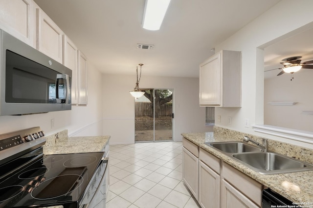 kitchen featuring sink, white cabinets, decorative light fixtures, light tile patterned floors, and appliances with stainless steel finishes