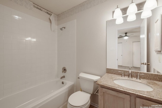 full bathroom featuring vanity, tiled shower / bath combo, toilet, and ceiling fan