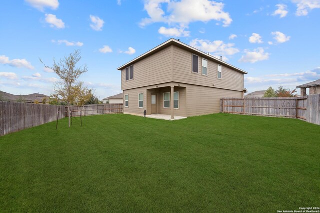 rear view of house with a lawn and a patio