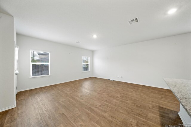 unfurnished room featuring a wealth of natural light and hardwood / wood-style floors