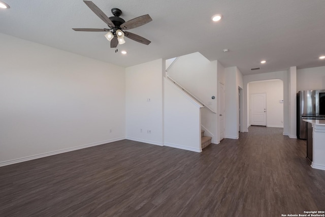 unfurnished living room with ceiling fan and dark wood-type flooring