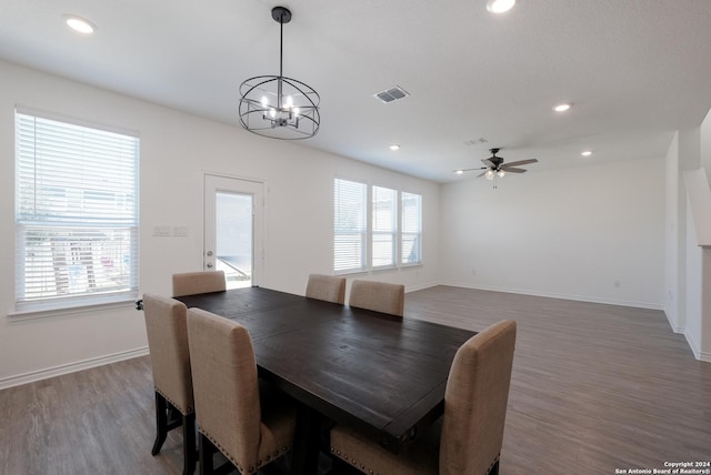 dining room featuring ceiling fan with notable chandelier, dark hardwood / wood-style flooring, and a wealth of natural light