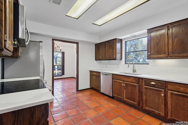 kitchen with tile patterned flooring, sink, dark brown cabinetry, and stainless steel appliances