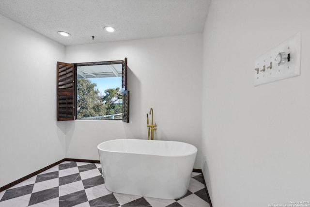 bathroom featuring a bathing tub and a textured ceiling