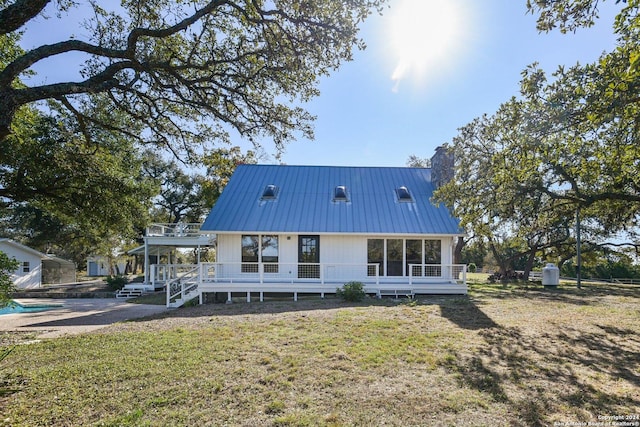 rear view of house featuring a yard and a wooden deck