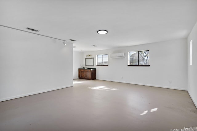 unfurnished living room featuring a wall mounted air conditioner