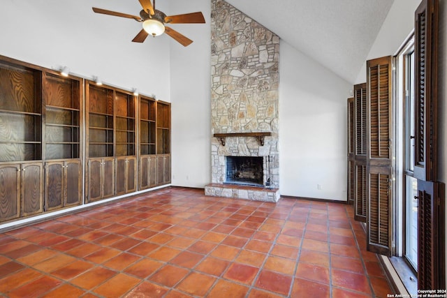 unfurnished living room featuring tile patterned flooring, high vaulted ceiling, and a stone fireplace