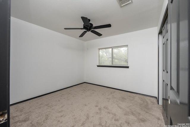 spare room featuring ceiling fan and light colored carpet