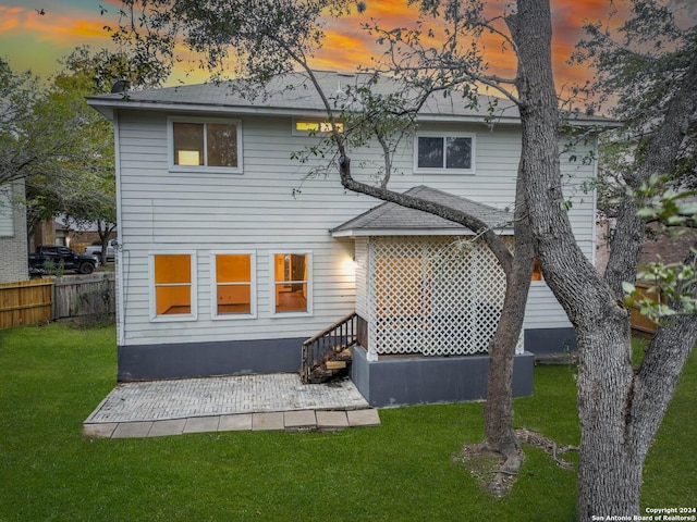 back house at dusk with a yard